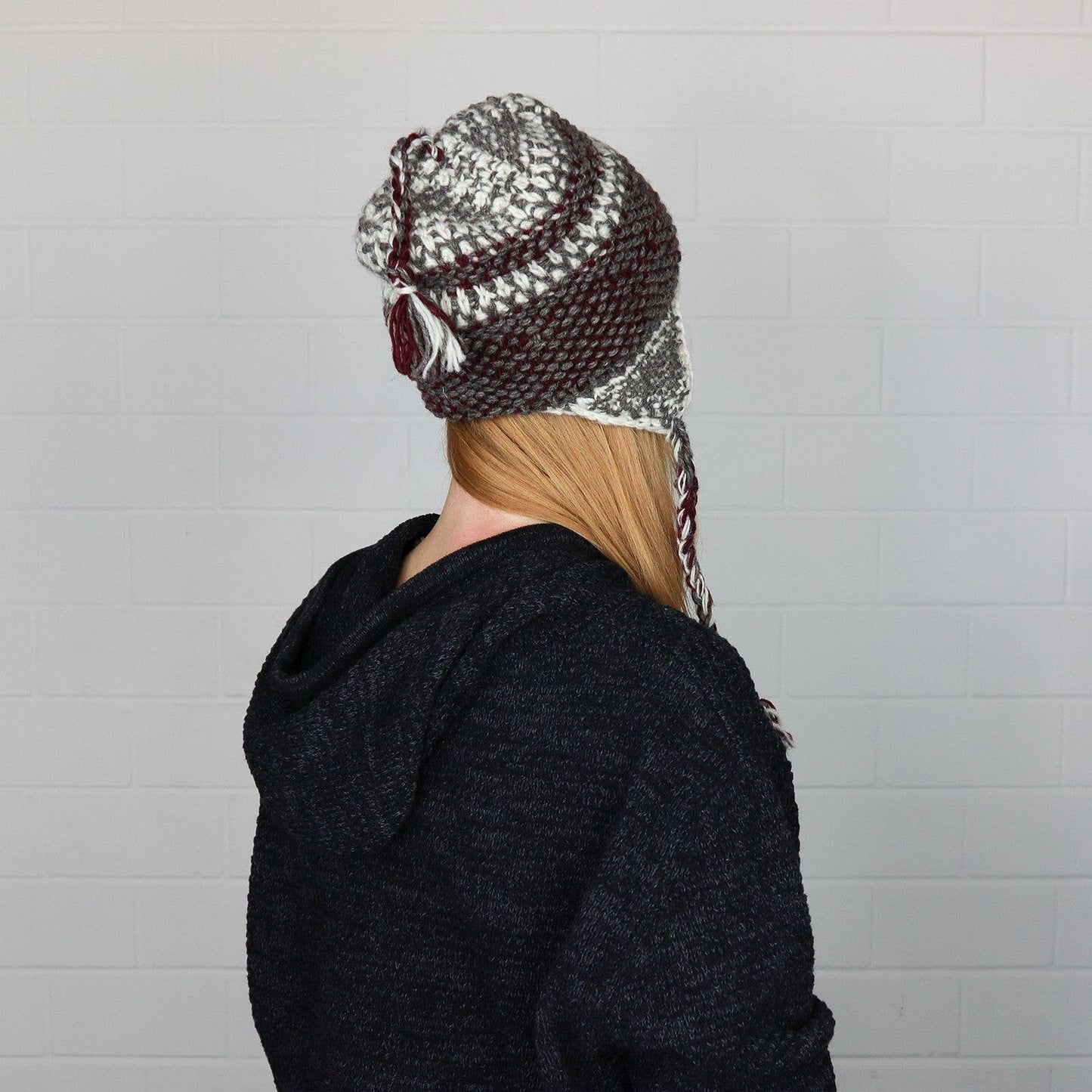 Stickad mössa med snören och öronlappar